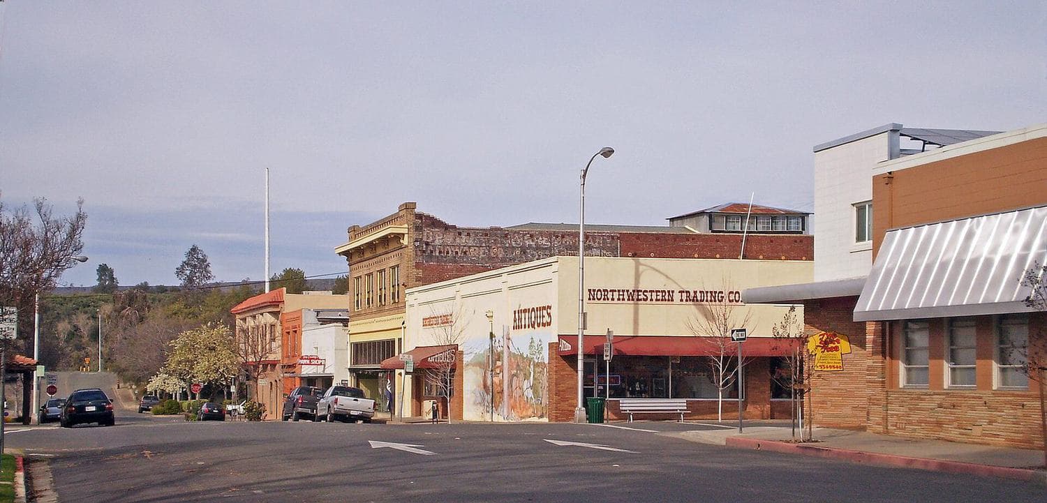 Row of historic brick and stucco commercial buildings with storefront windows in downtown Oroville, California